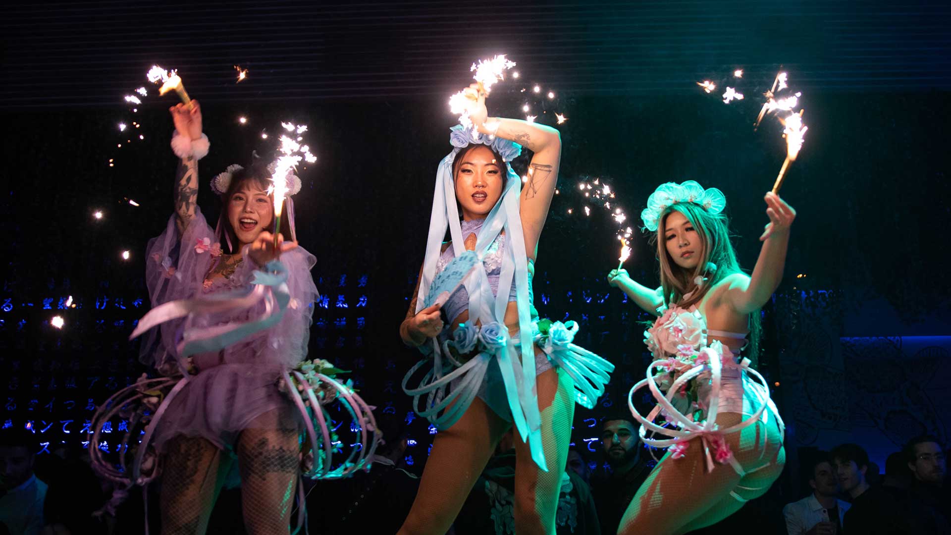 3 female dancers giving a show with fire